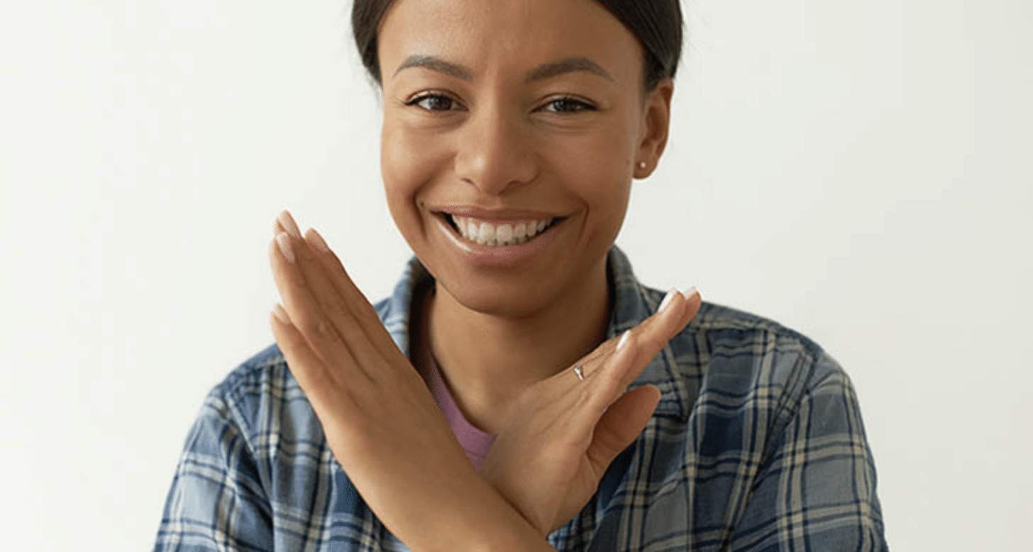 Woman smiling and holding her hands in an x motion