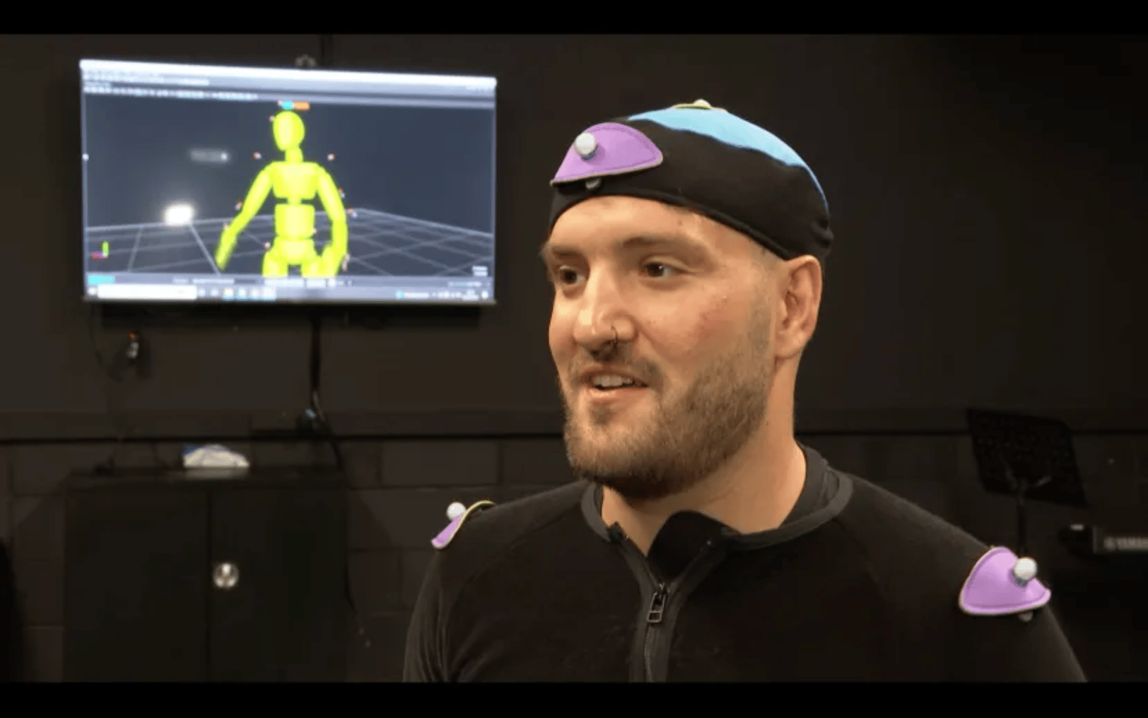Andy Dickenson with motion capture suit on talking to ITV interviewer