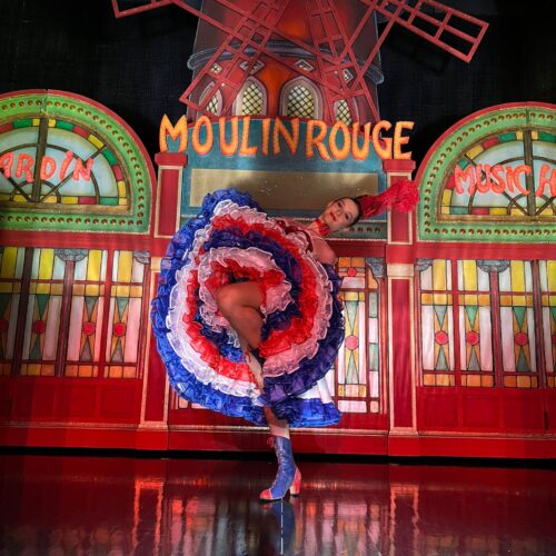 Erin in costume poses on the Moulin Rouge Stage